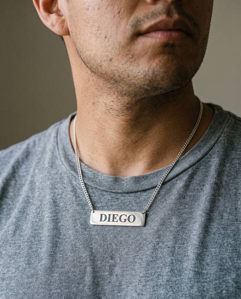 Hombre con placa de plata con el nombre Diego