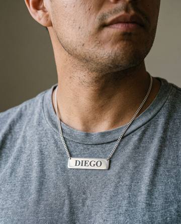 Hombre con un collar de placa de plata con el nombre Diego